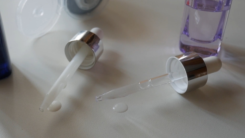 Staklene pipete sa serumom za negu problematične kože na svetloj podlozi