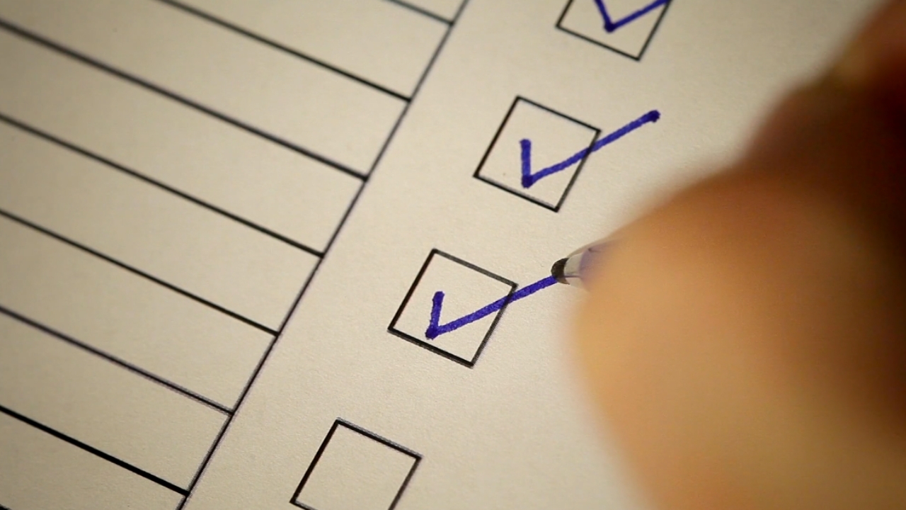 Osoba hemijskom olovkom označava kvačice u kvadratićima na listi