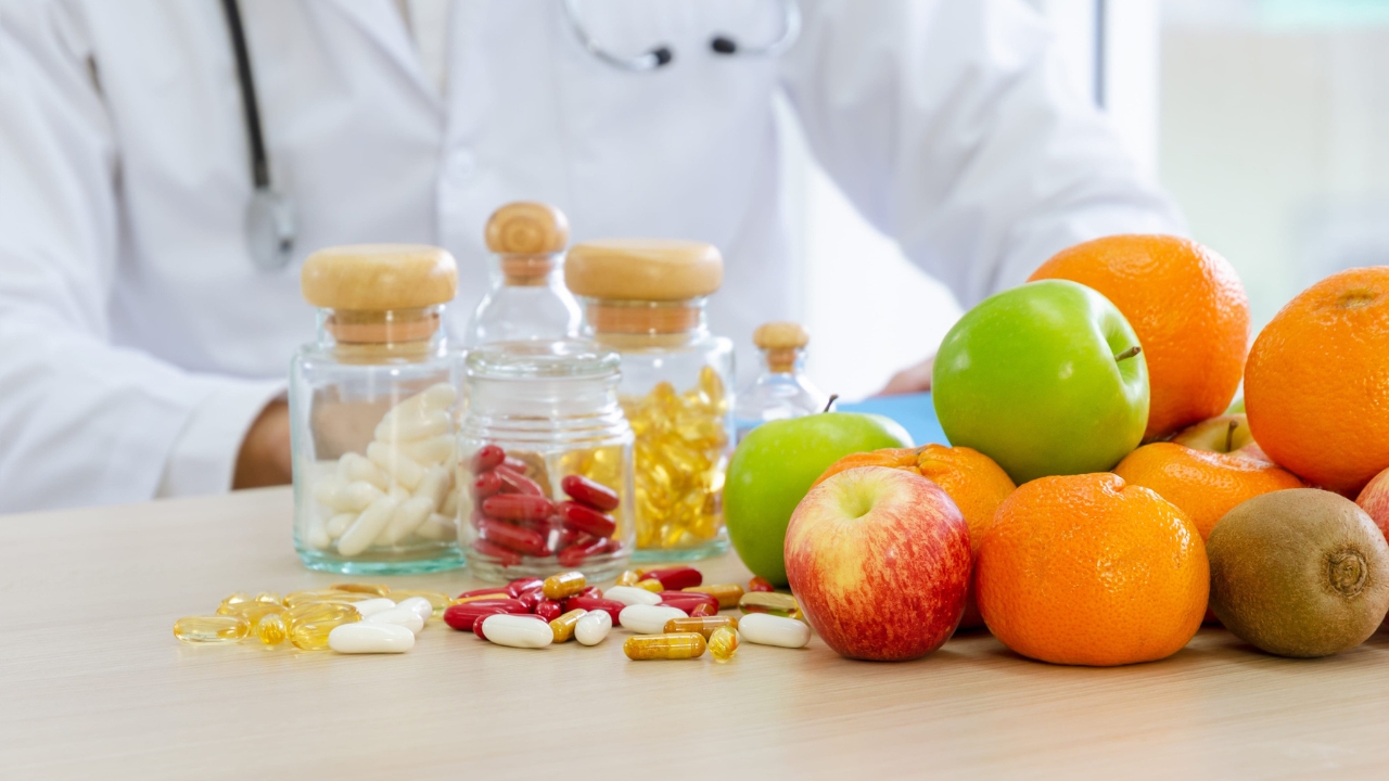 Voće i vitaminski suplementi na stolu pored lekara.